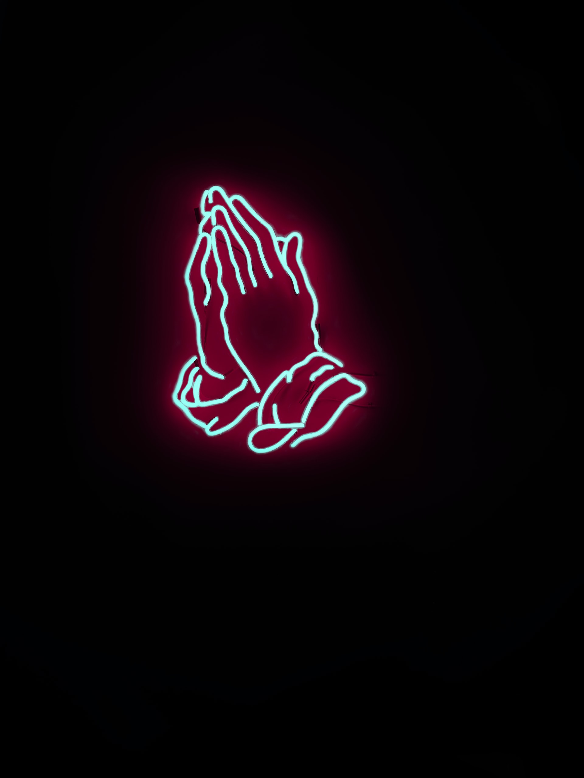 Neon red sign of hands praying