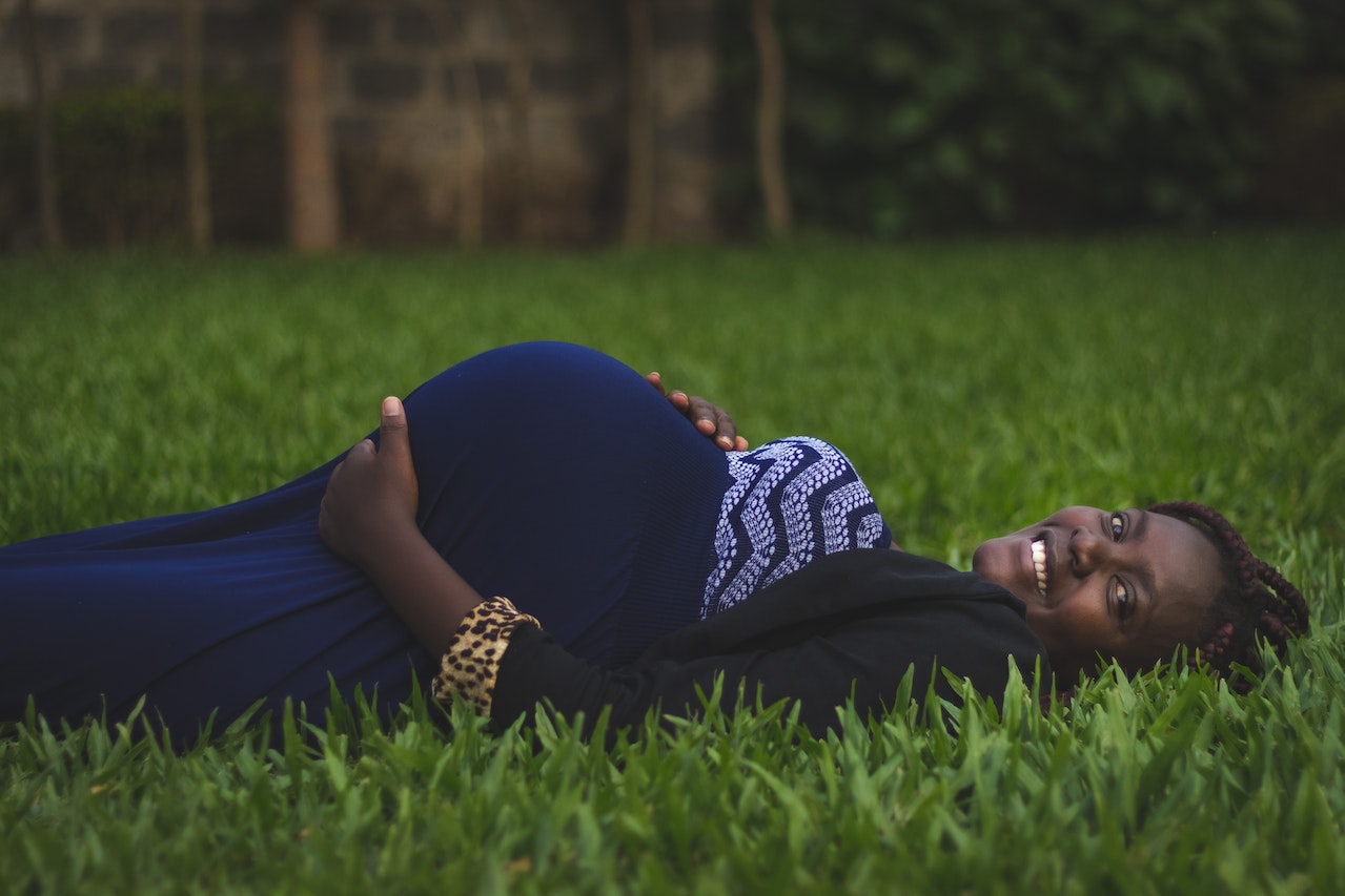 Pregnant Woman Lying on Green Grass Field