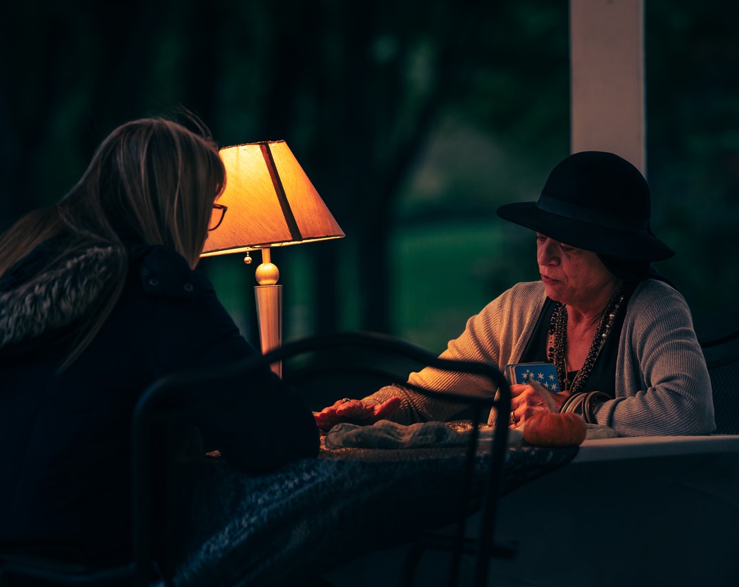 A Woman reading Tarot Cards in front of a client