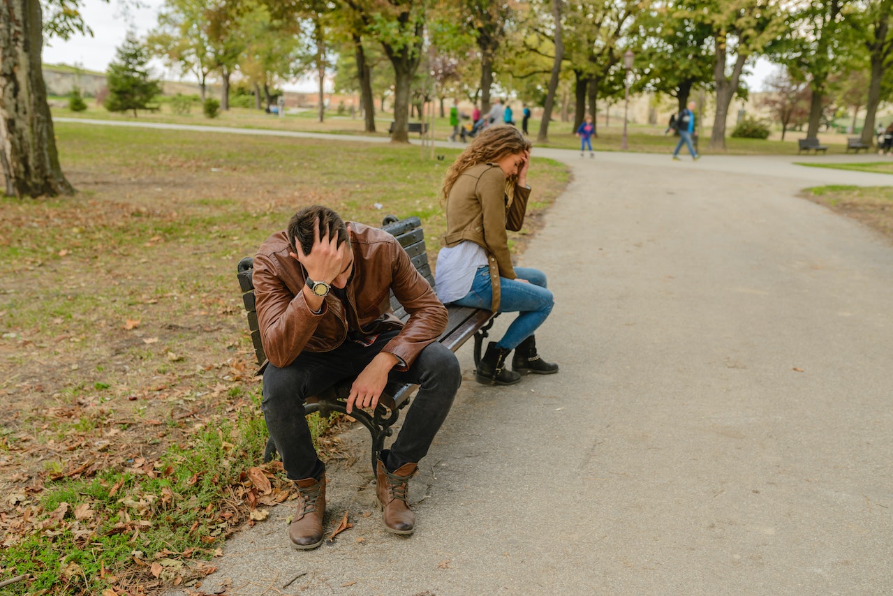 Man And Woman Sitting On Bench that seems to be fighting