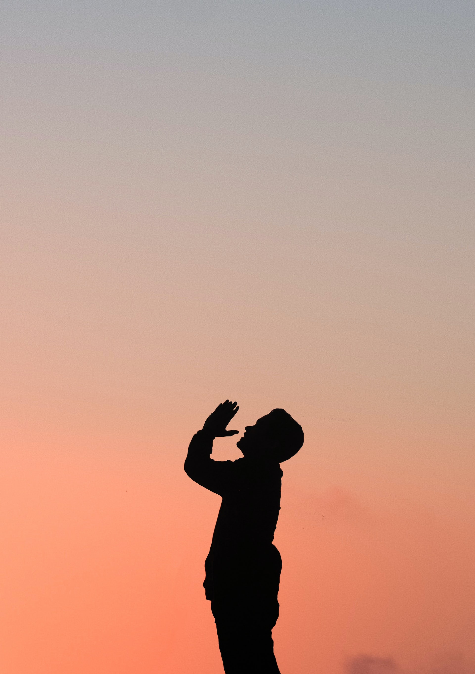 Man praying during a sunset