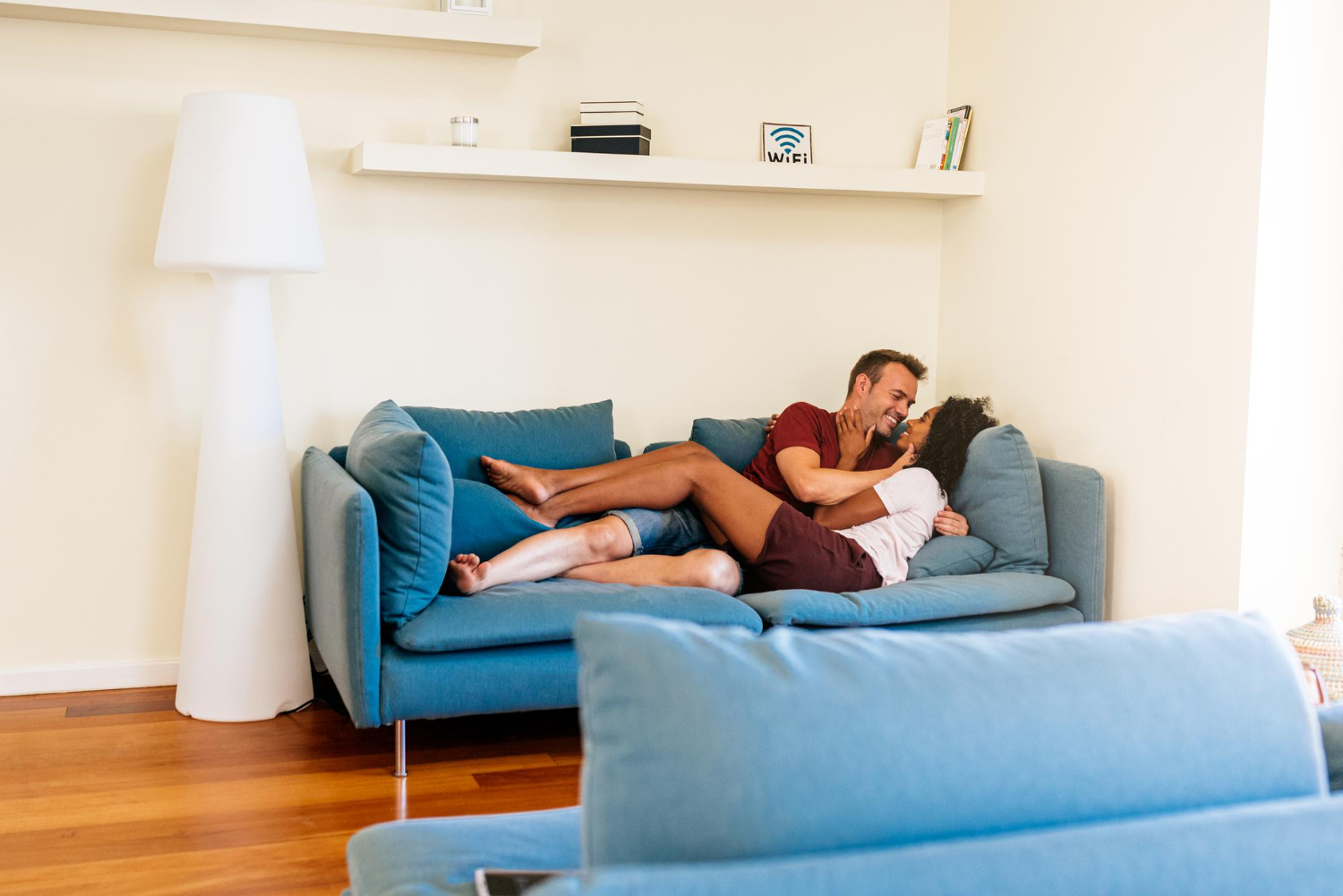 A couple is looking at each other on a sofa
