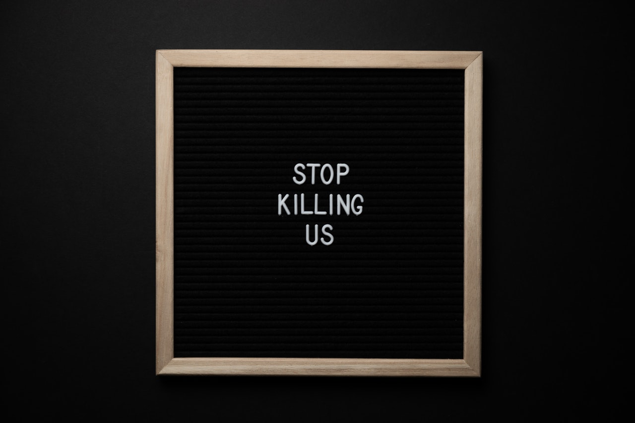 Phrase Stop Killing Us on a Black Signboard