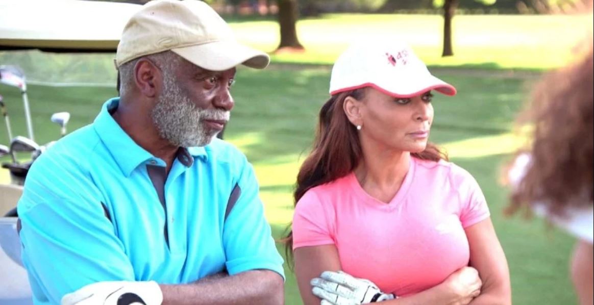 Ray Huger and his wife Karen Huger on a golf court wearing golf attire
