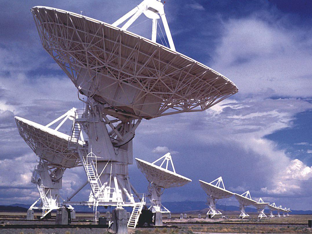 Several white radio telescope pointing to the sky