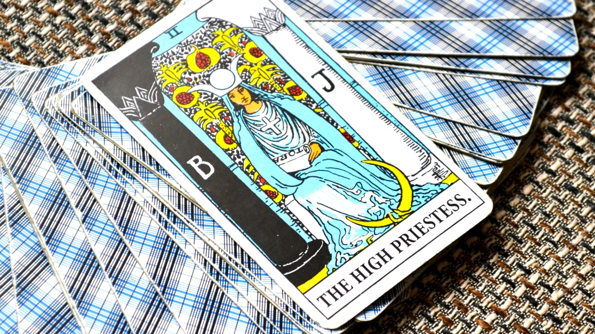 A tarot card deck with High Priestess card facing Upright 