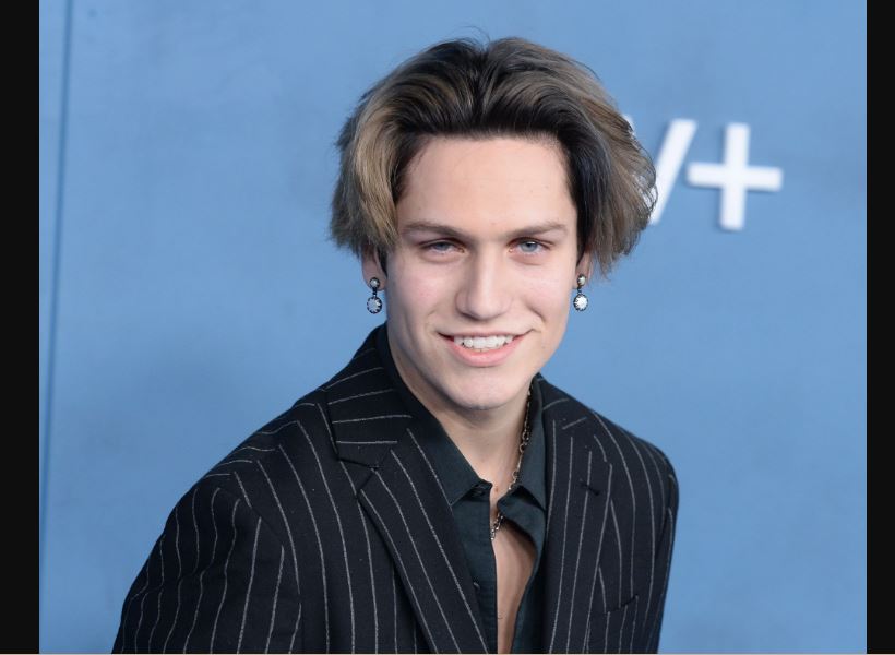 Chase Hudson wearing a black suit at an event