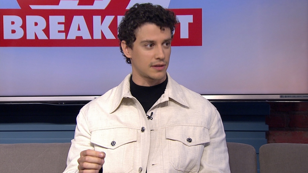Adam DiMarco wearing a white jacket during an interview