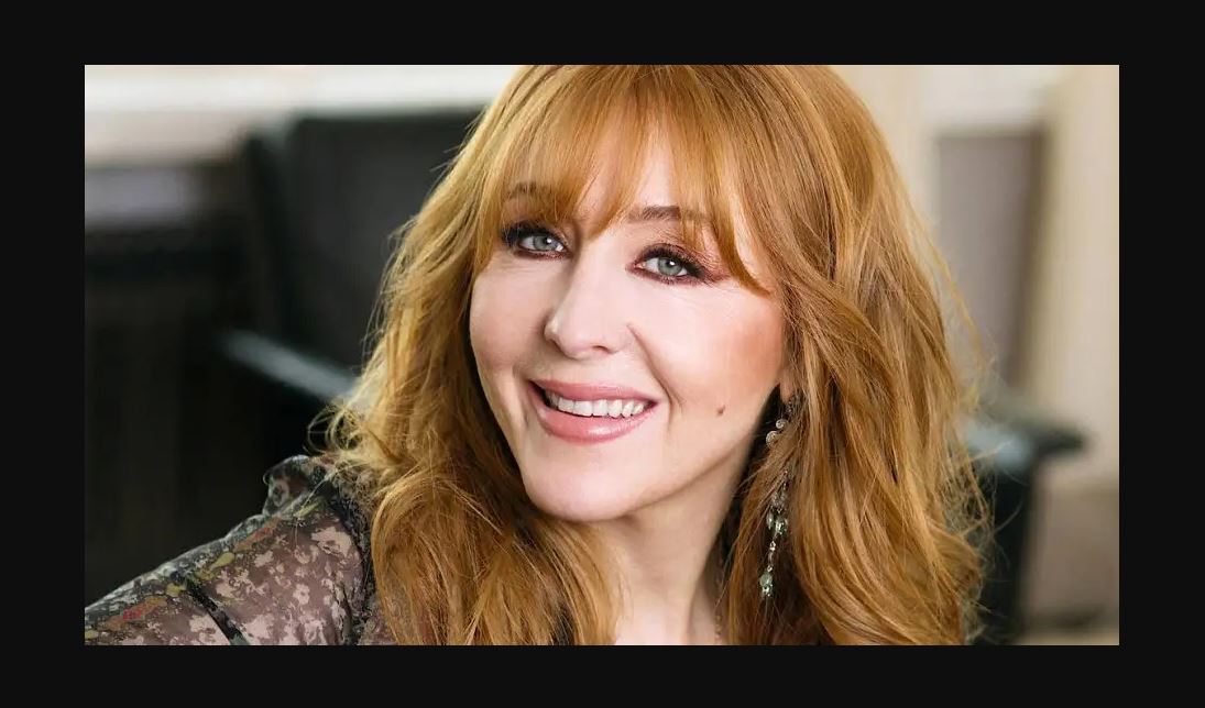 Charlotte Tilbury wearing a pink lips and a smile on her face