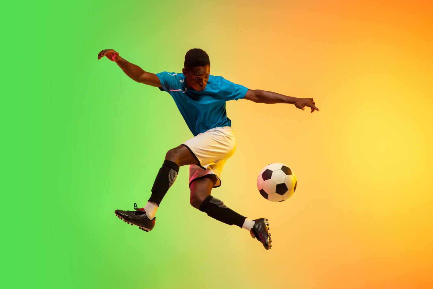 A football player kicking a ball in mid-air