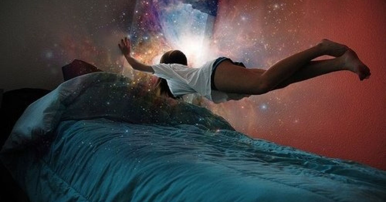A lady hovering above her bed while dreaming
