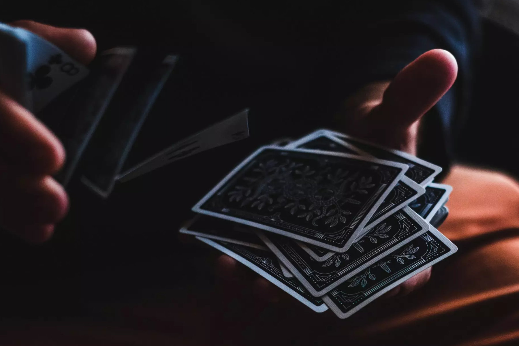 A man's hand shuffling a deck of cards