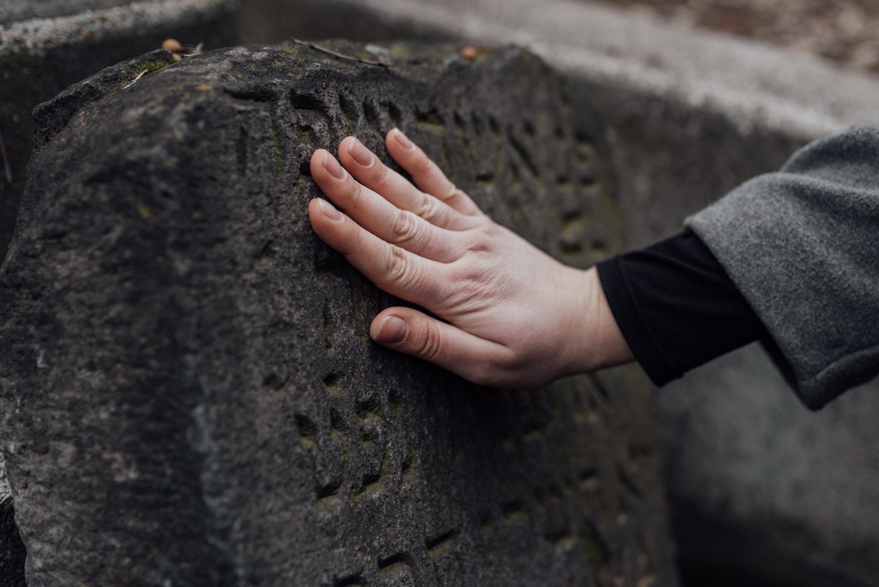 A Person Touching a Stone with Carvings