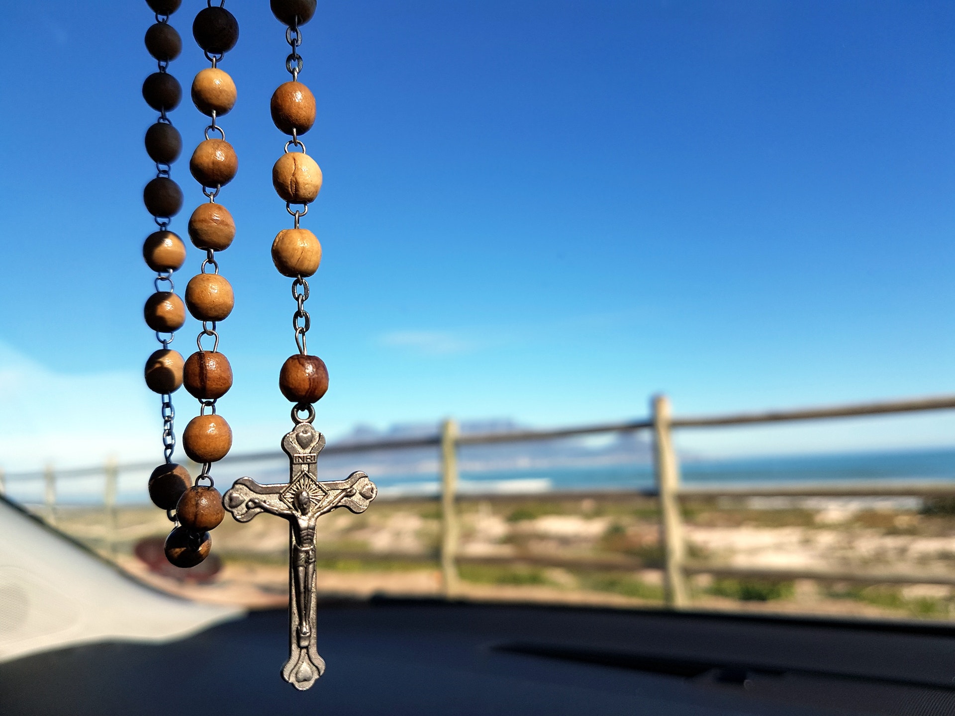 A hanging brown Catholic rosary with the cross