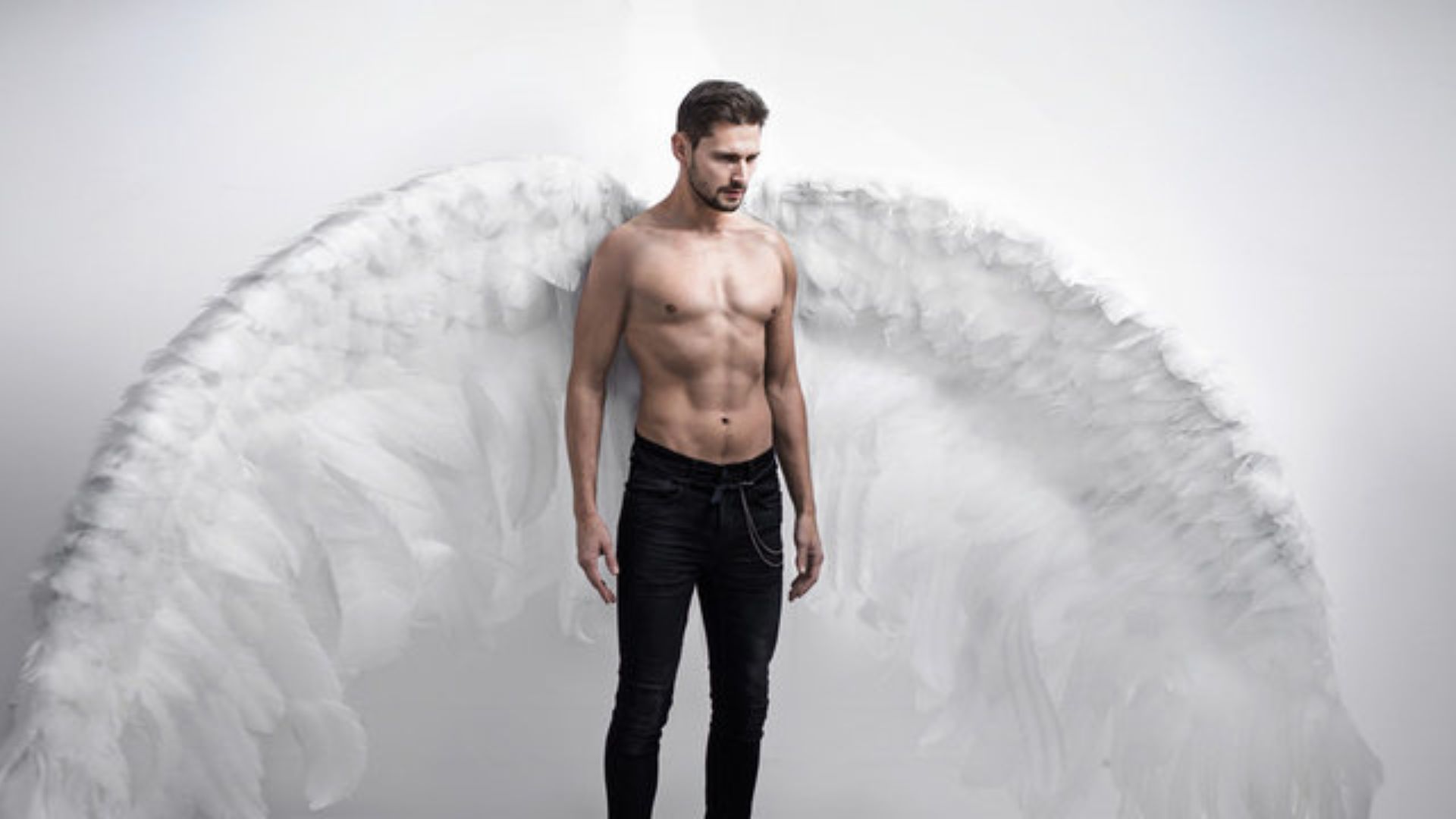 A Topless Man With White Wings