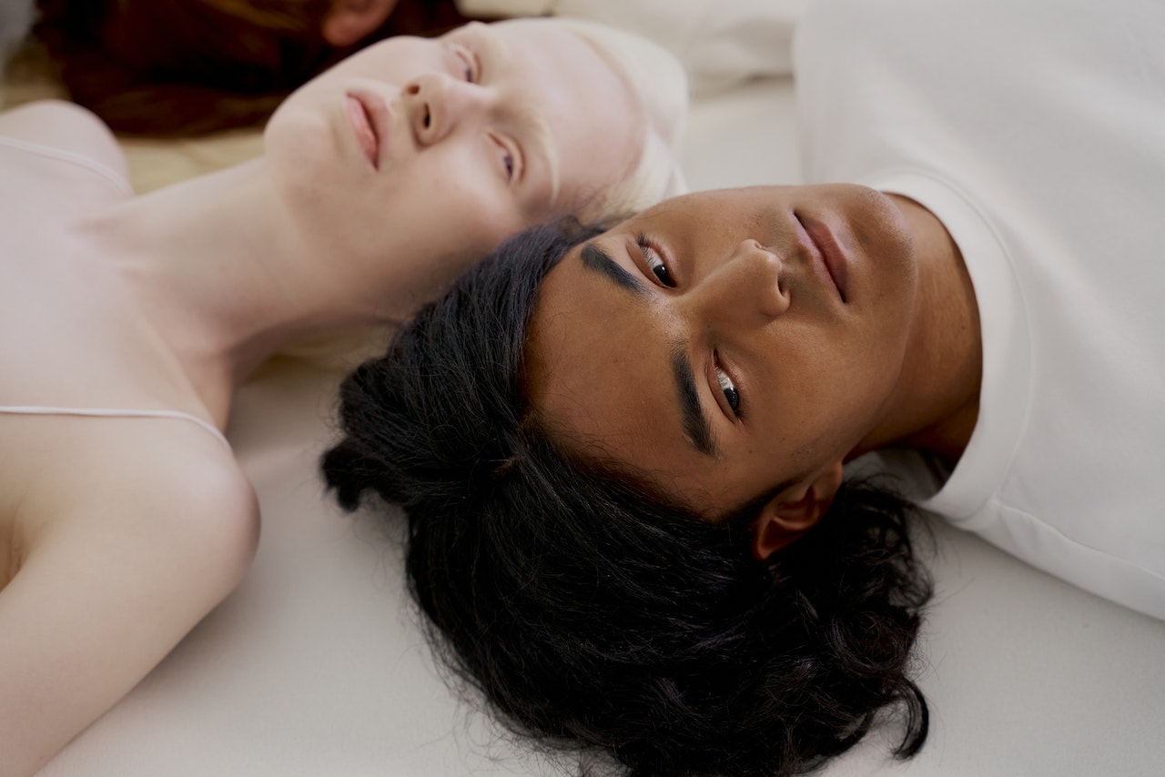 Man and Woman Lying on White Surface