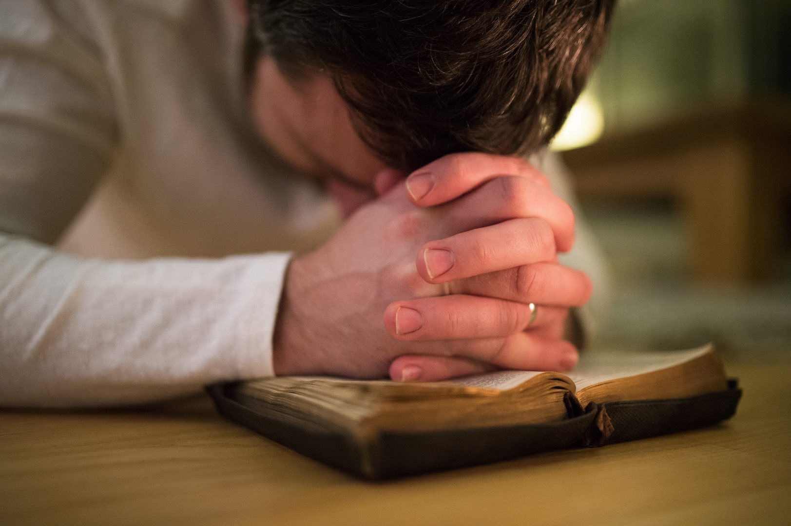 A man praying on a bible