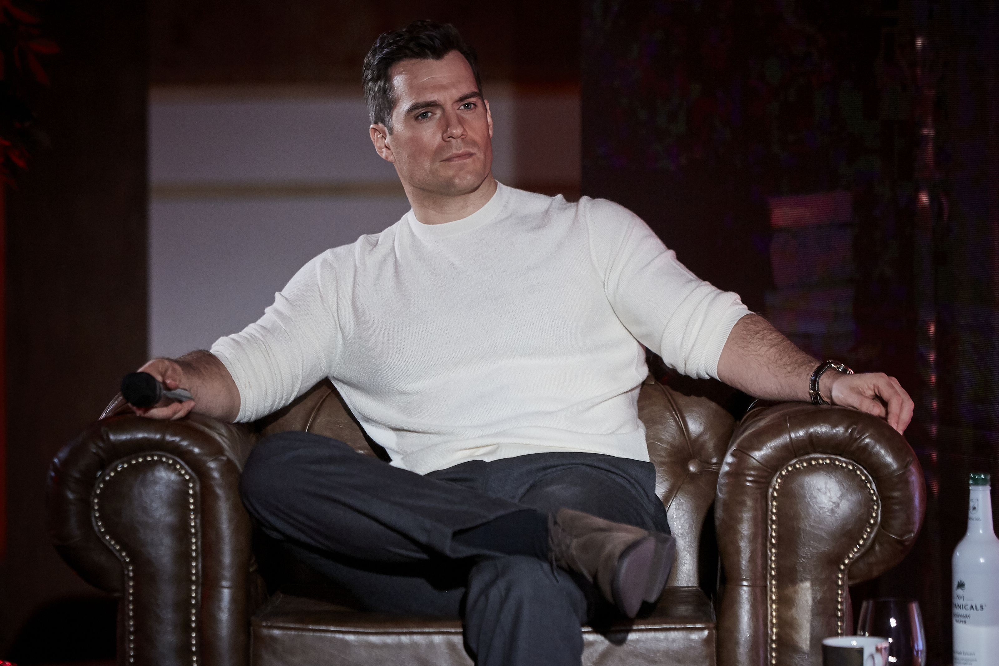 Henry Cavill sitting in an armchair