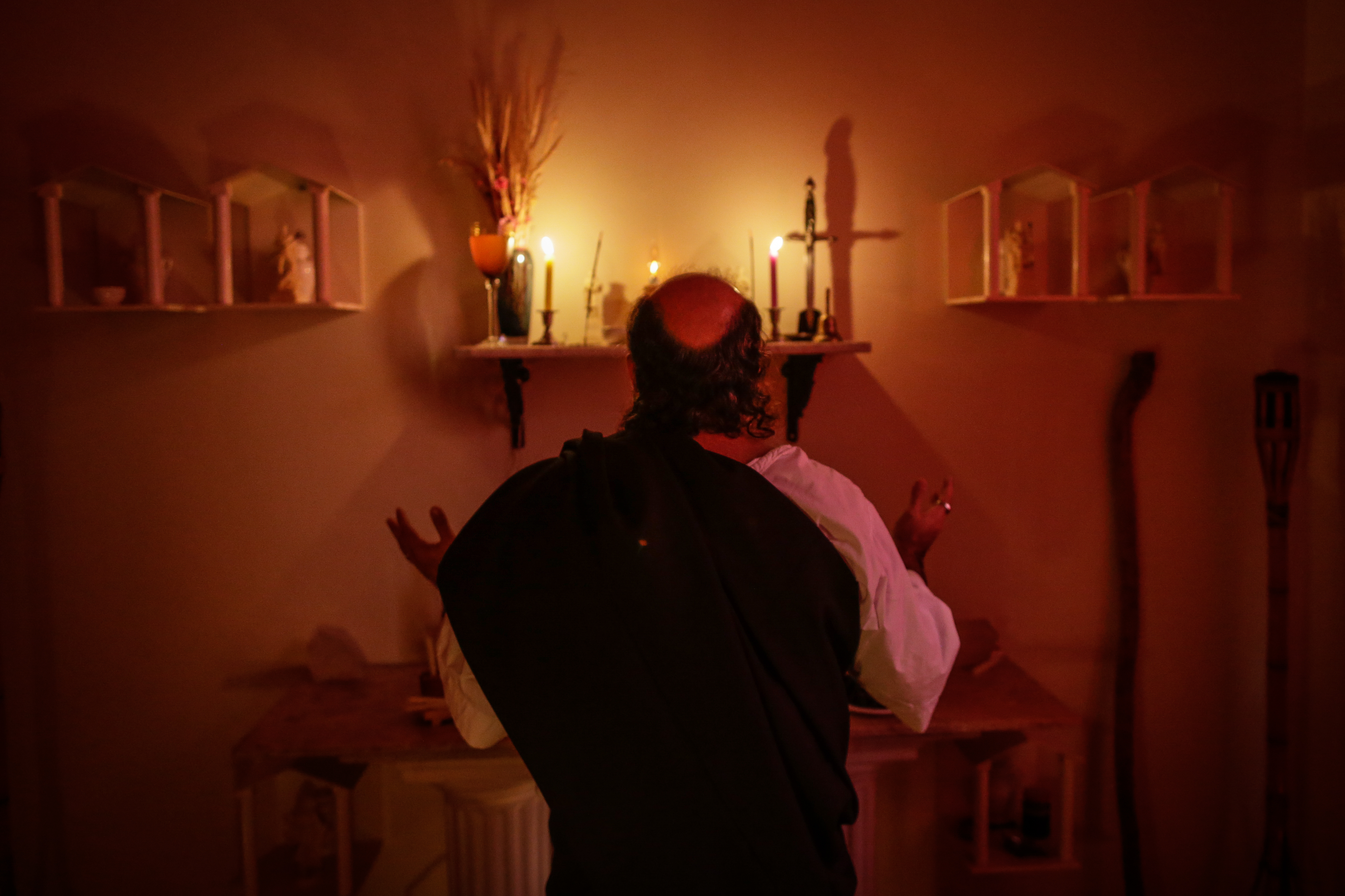 An Old Man Worshiping In Front Of Candles
