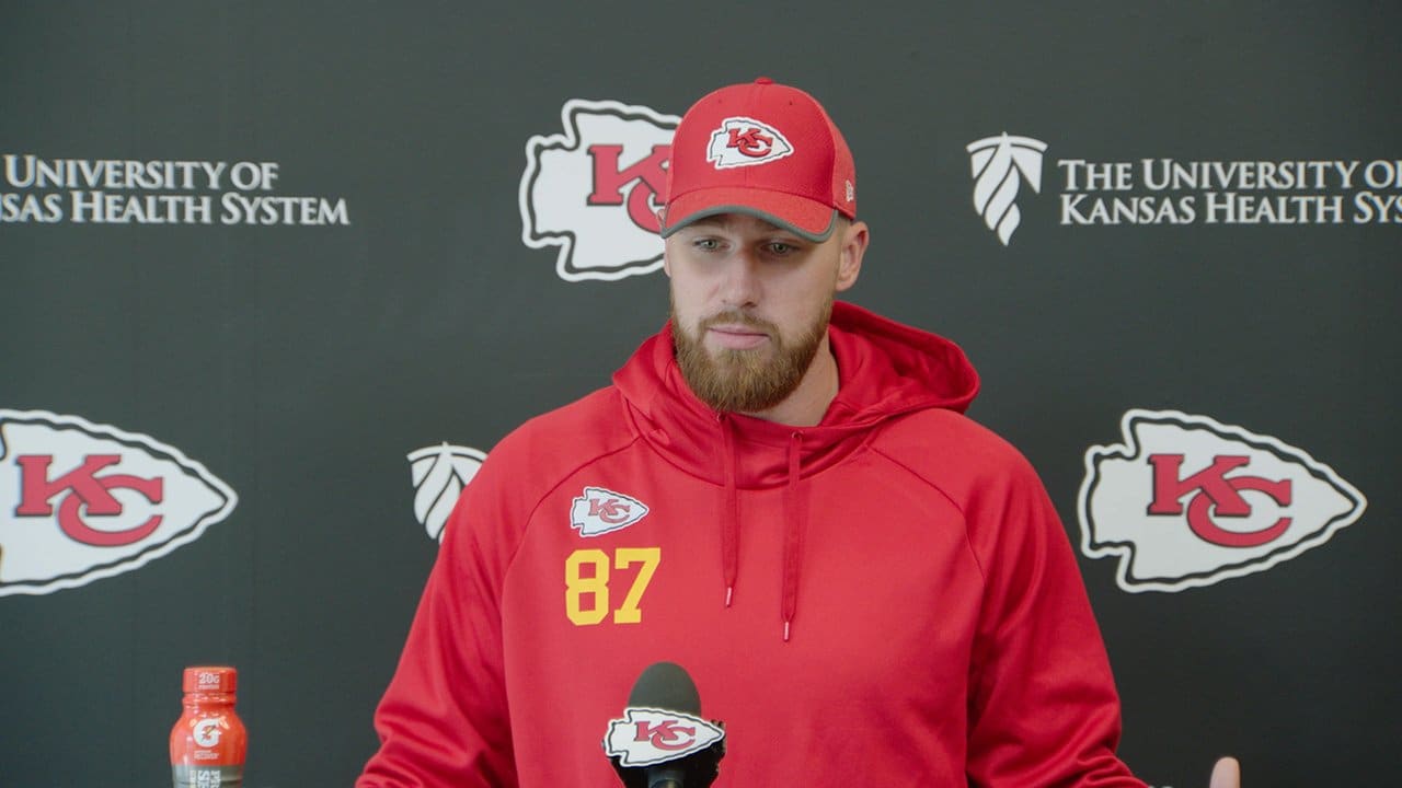 Travis kelce wearing a red jacket and cap