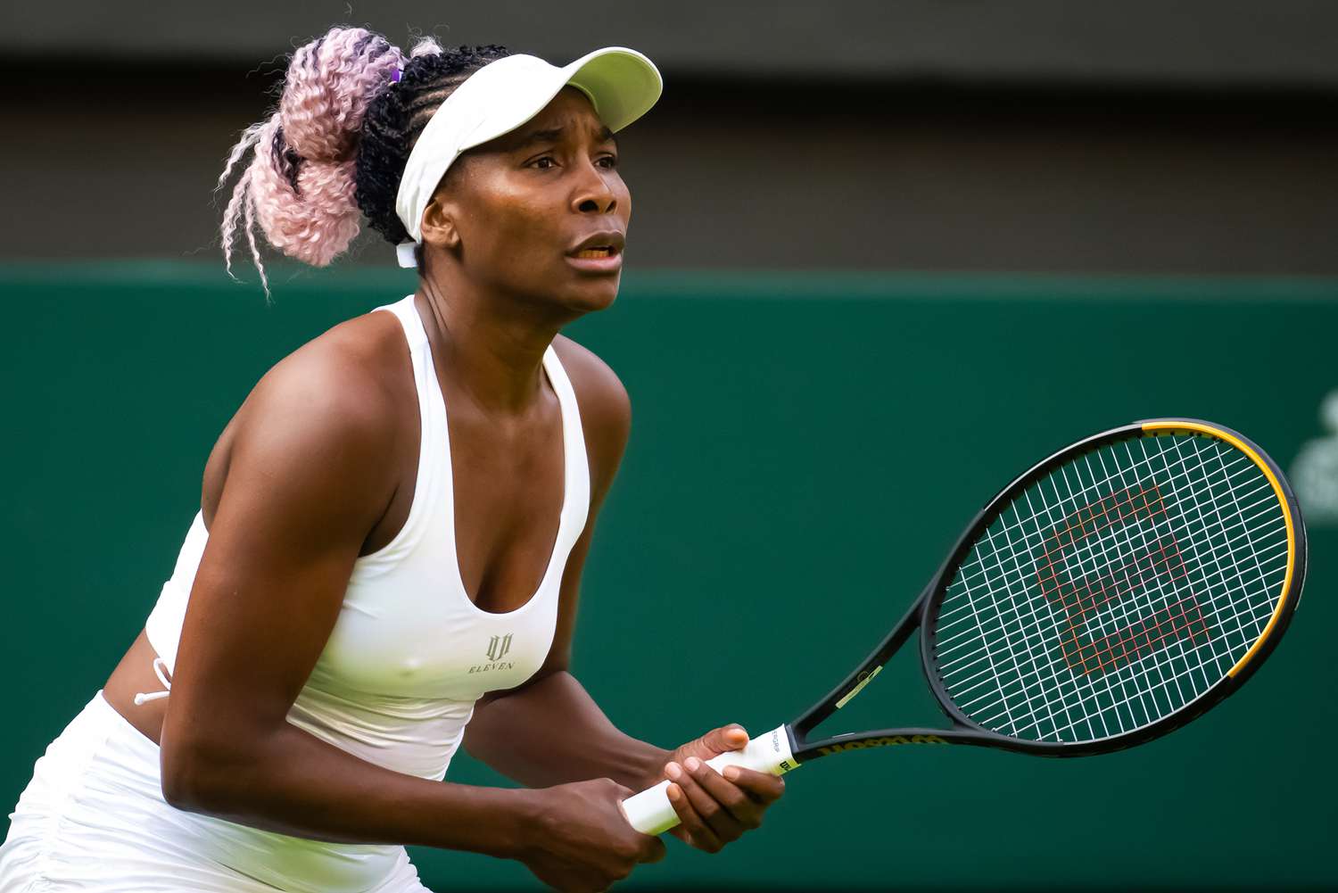 Venus Williams wearing a white sports outfit while holding a tennis racket