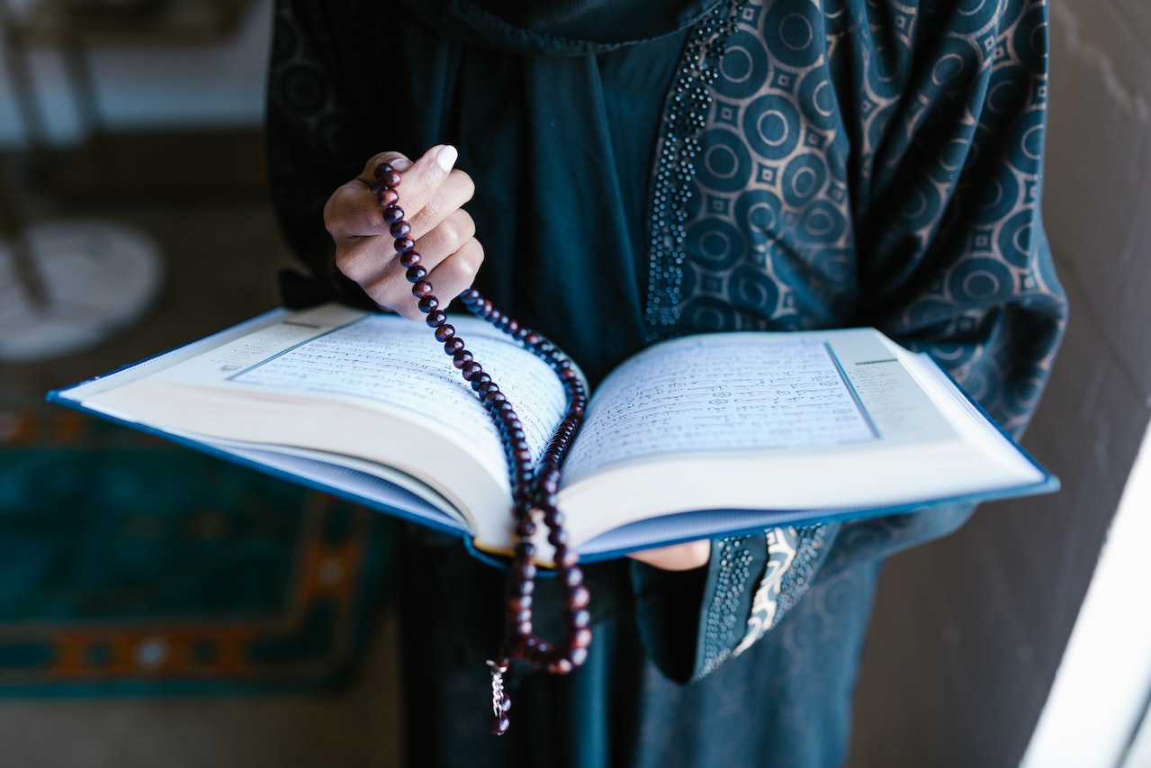 Woman Holding A Prayer Beads And Holy Book