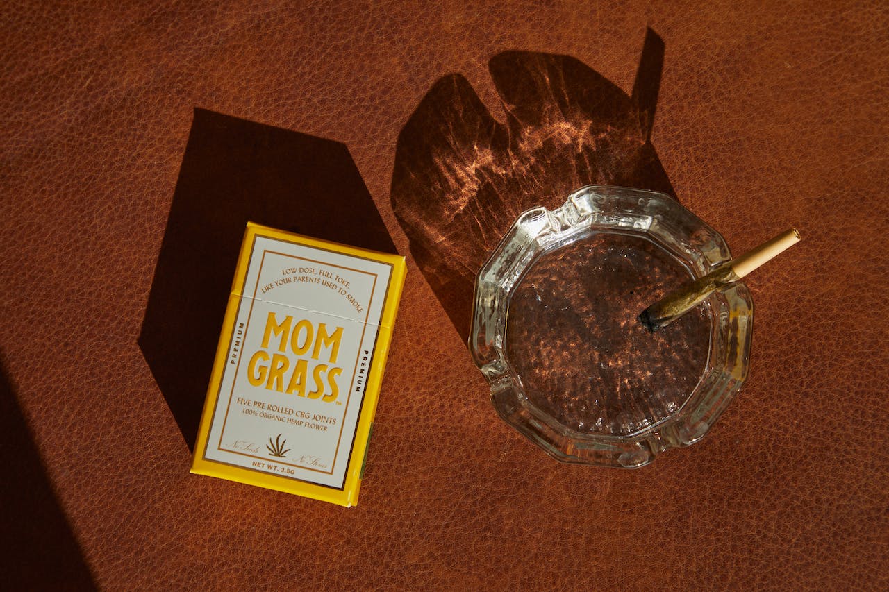 A Pack of Mom Grass and an Ashtray on a Surface