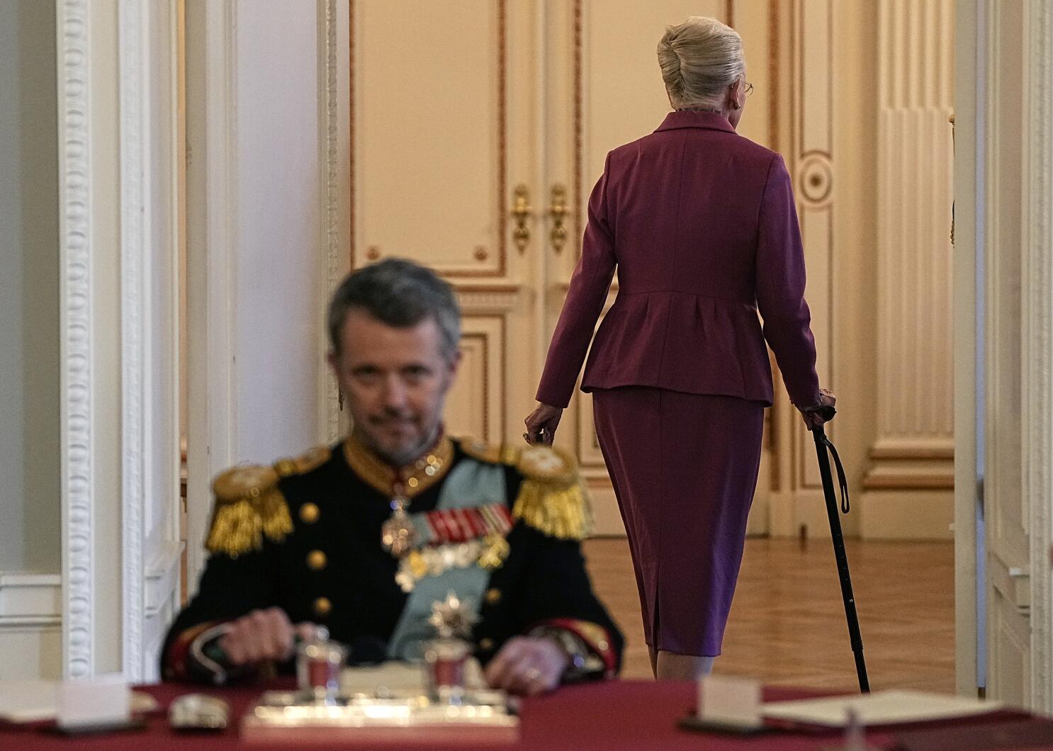 King Frederik sitting as his mother Queen Margrethe walks aways