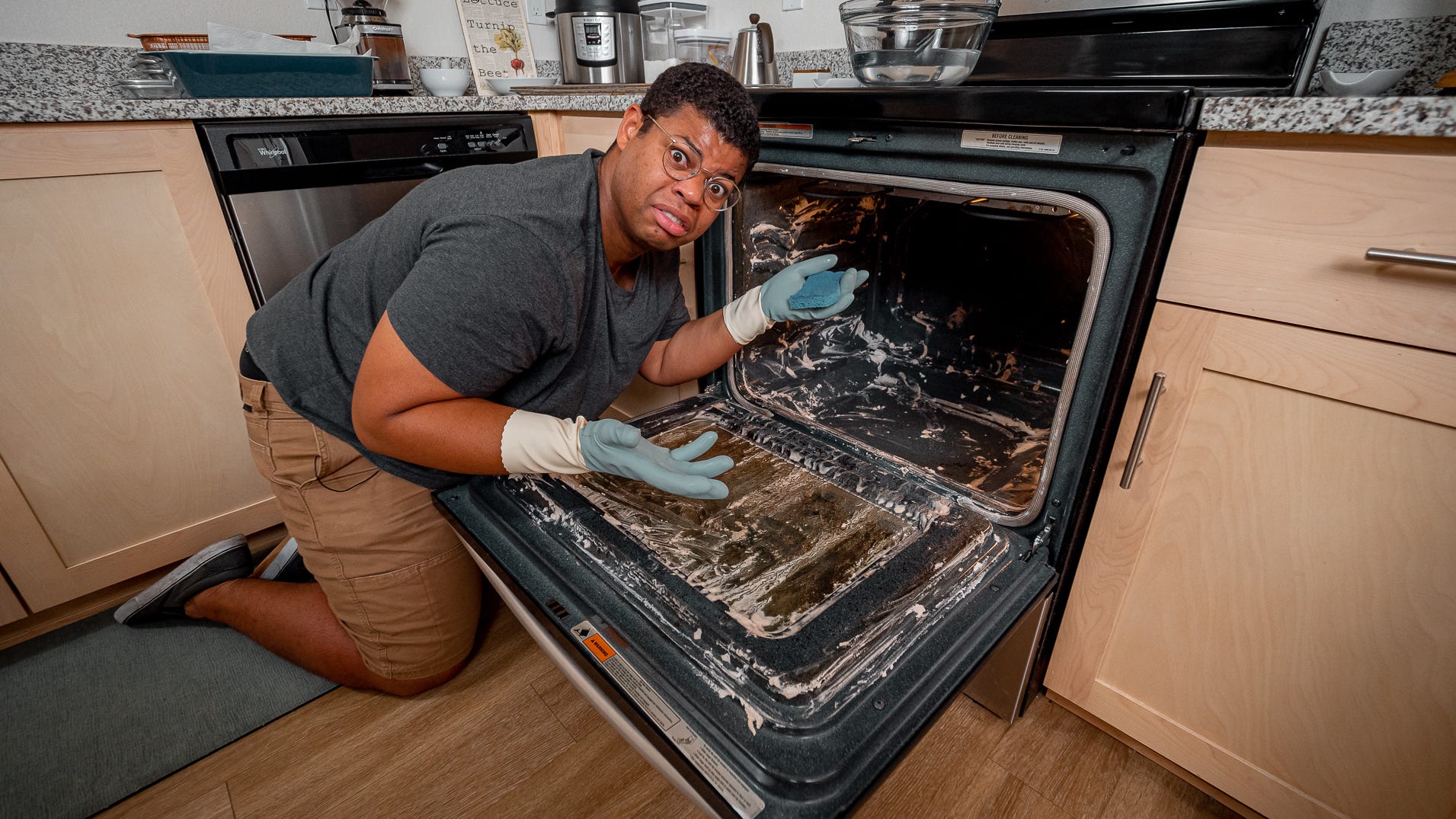 A Man Cleaning A Dirty Oven